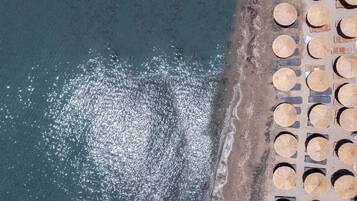 Aan een privéstrand, wit zand, gratis strandhuisjes, ligstoelen