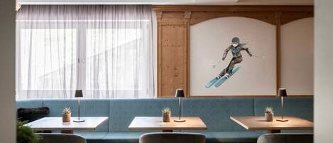 A modern interior with a seating area, tables, and a wall mural.