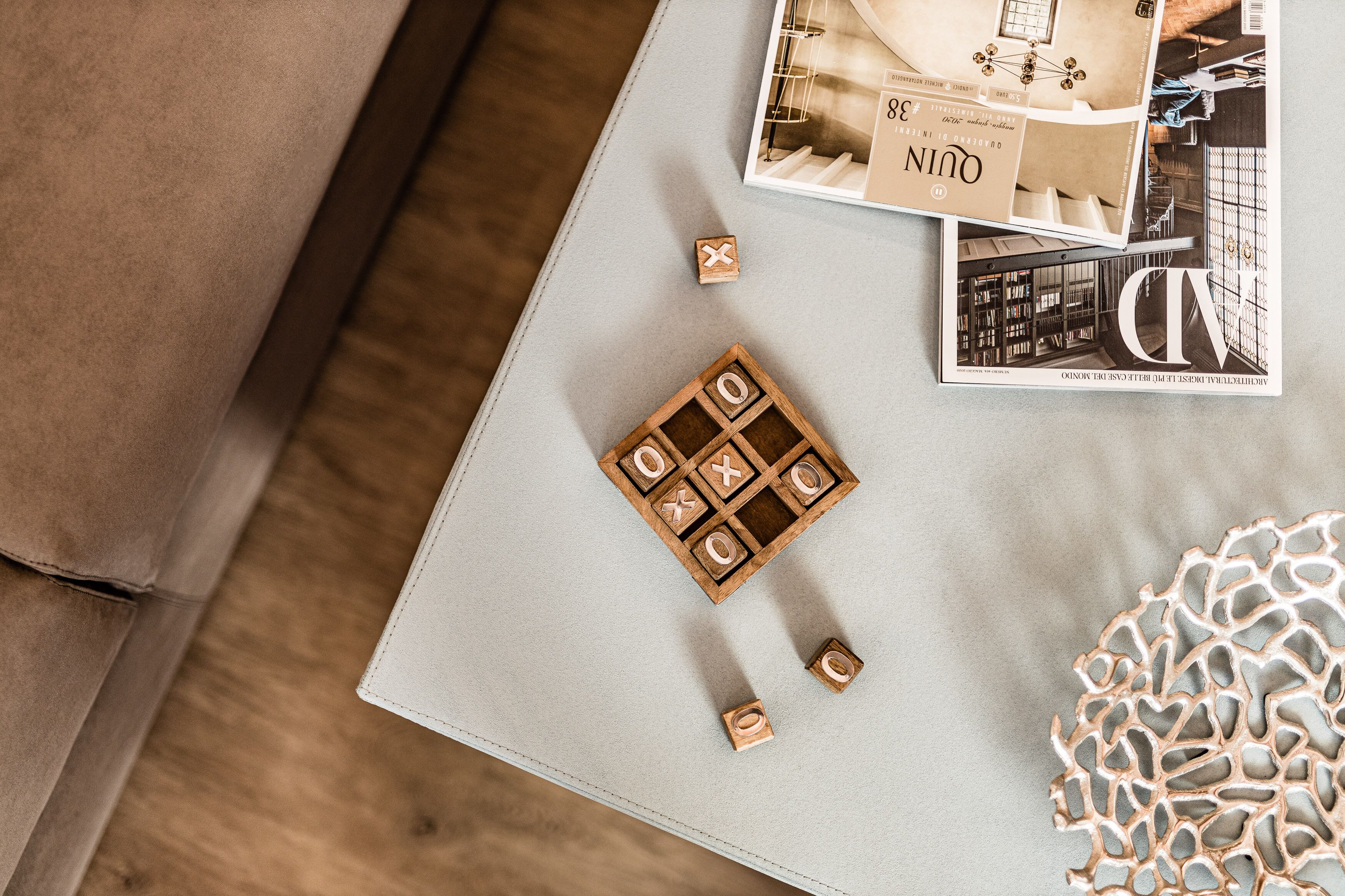 Revista sobre uma mesa com um jogo de blocos de madeira e um objeto decorativo.