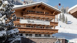 A multi-story wooden building with a sign reading 'Grindina Boutique Hotel B&B.' - Giardin Boutique Hotel B&B (Selva di Val Gardena)