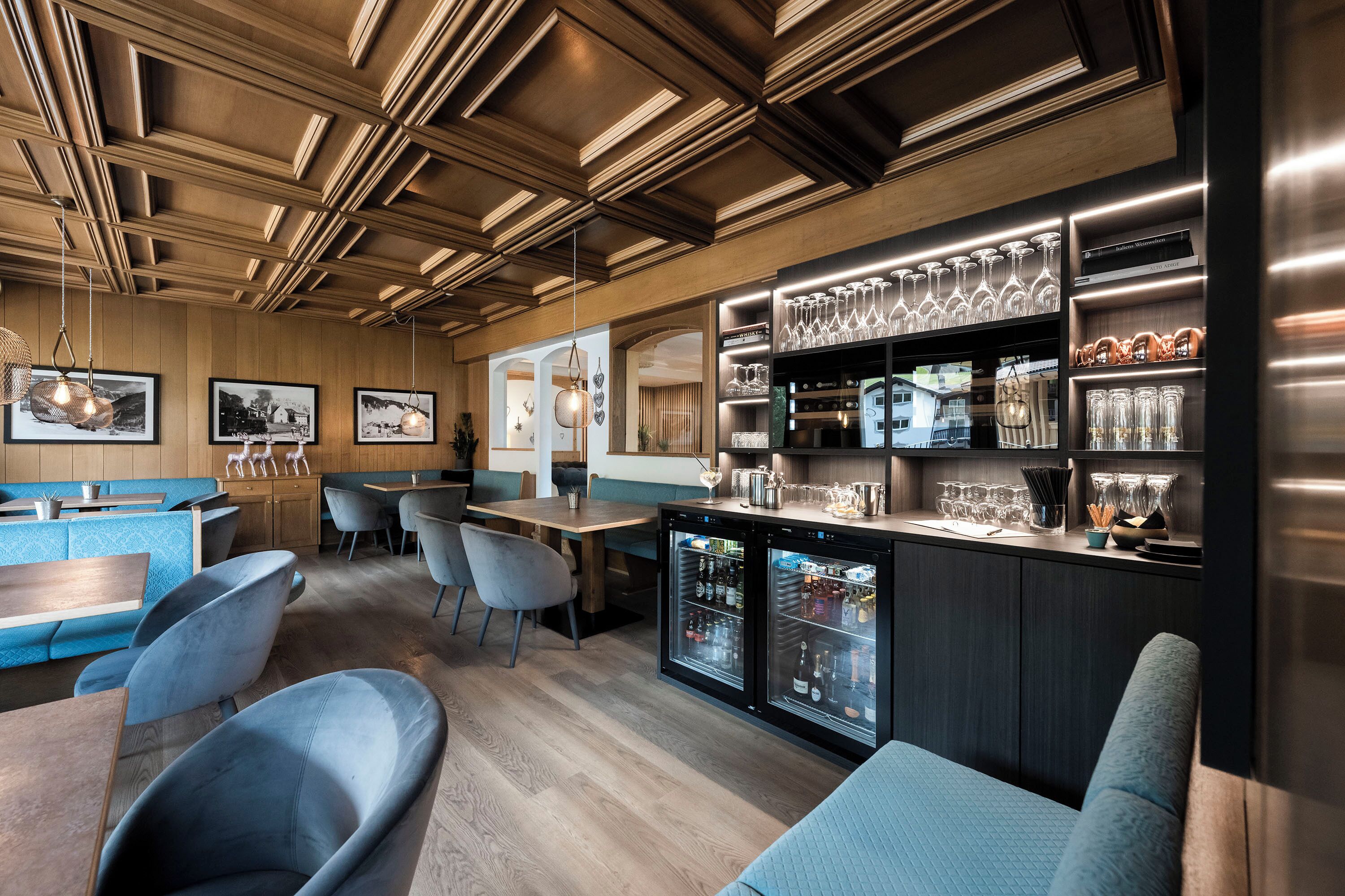 Un espace bar moderne avec des panneaux en bois, des sièges et un présentoir à vin.