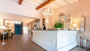 A spacious kitchen with a central island, wooden flooring, and a chandelier.