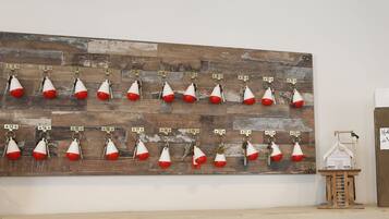 A wall-mounted key rack with numbered hooks, a small wooden model, and a sign reading "Hotelje de Verman".