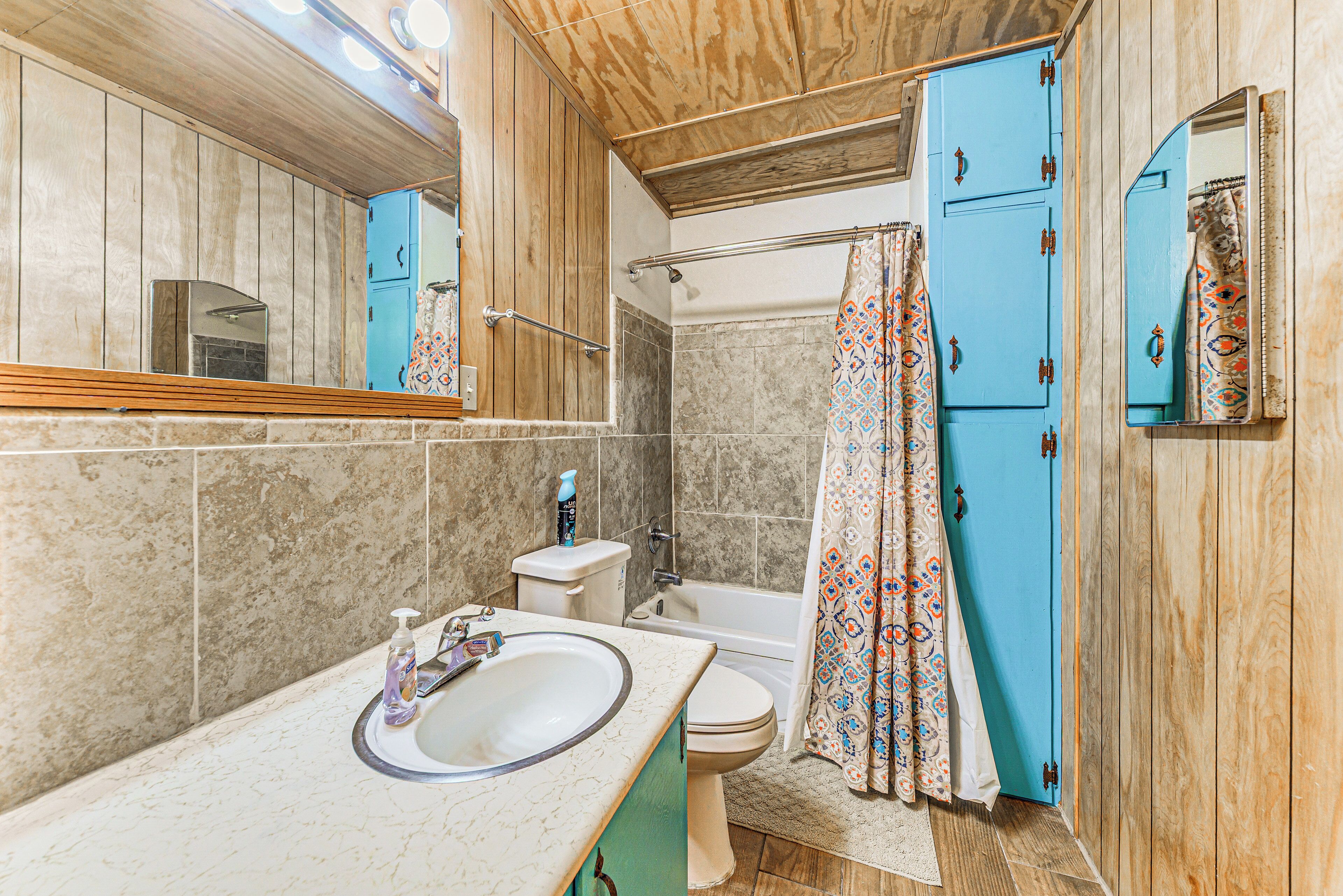 A bathroom with a sink, toilet, and shower.