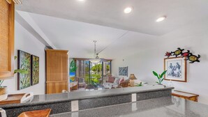 A modern kitchen with granite countertops, a wooden cabinet, and a dining area with a view.