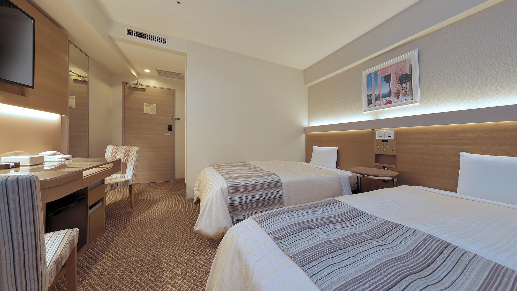 A hotel room with two beds, a desk with a chair, a flat-screen TV, and a painting on the wall.