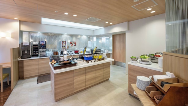 A modern kitchen with a central island, built-in appliances, and a seating area with a view. - Keio Presso Inn Gotanda (Tokyo)