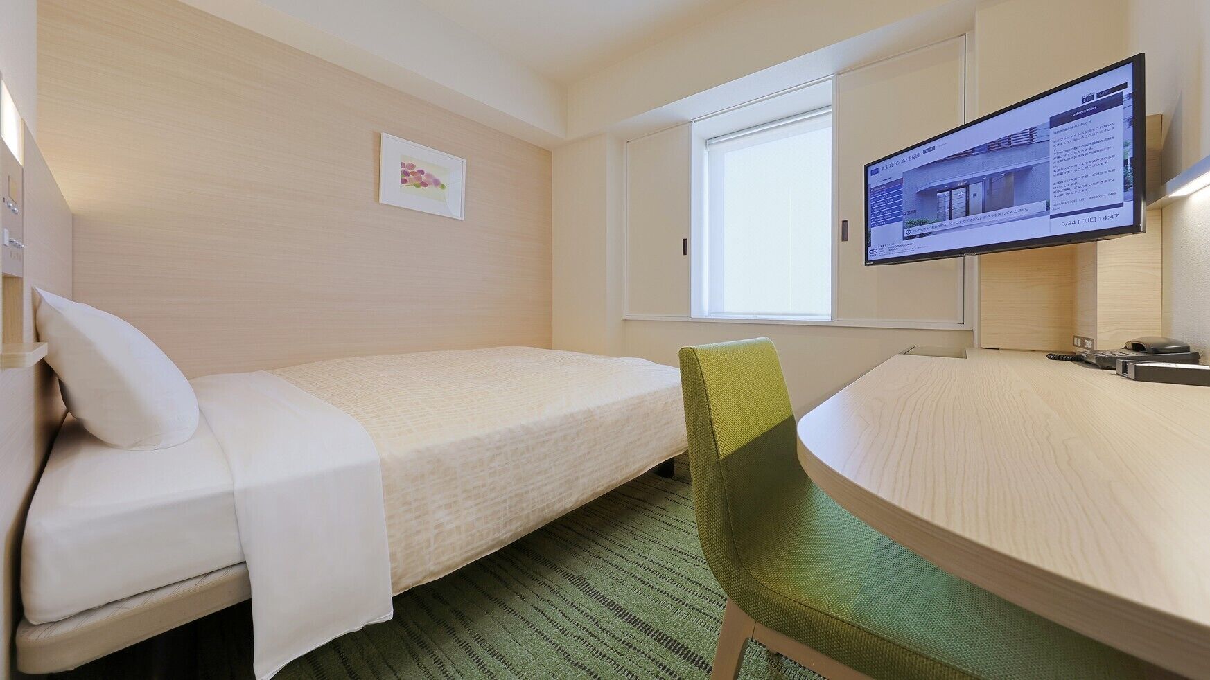 Una habitación de hotel con una cama individual, un escritorio, una silla, un televisor y una ventana.