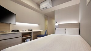 A hotel room with a bed, a desk with a flat-screen TV, a chair, and a wall-mounted air conditioner. - Keio Presso Inn Gotanda (Tokyo)