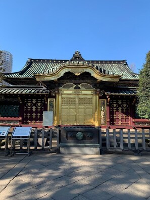 A traditional building with a prominent golden gate, a tiled roof, and a wooden fence in front. - Sunroute Stellar Ueno (Tokyo)