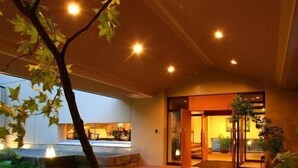 An indoor pathway leading to a building entrance with a tree in the foreground. - Spa Esthetique Suichokan (Sapporo)