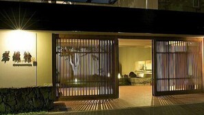 A modern building with a large entrance gate, a visible sign with characters, and a moon in the sky. - Spa Esthetique Suichokan (Sapporo)