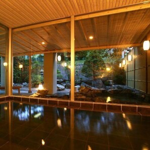 A spacious indoor area with a wooden ceiling, large windows, and a reflective floor. - Spa Esthetique Suichokan (Sapporo)