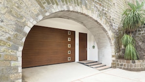 An arched stone entrance with a wooden door and a staircase leading inside. - Villa Manning Relais (Sorrento)