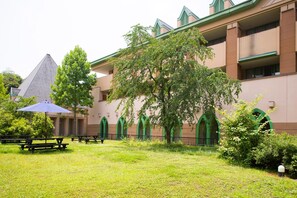 A building with arched windows and a pyramid-shaped structure in the background. - Hotel Tango Okoku (Kyotango)