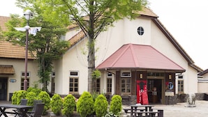 Een gebouw met een rood dak, een klein raam en een bord met Japanse tekens.