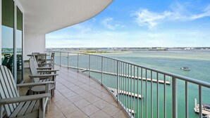 Ein Balkon mit Stühlen und Blick auf ein Gewässer.