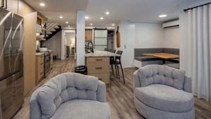 Un espace de vie compact comprenant une cuisine, un coin repas et un espace détente.