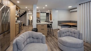 Um espaço de estar compacto com cozinha, sala de jantar e área de estar.