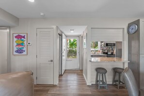 A modern kitchen with a built-in oven, microwave, and a clock on the wall.