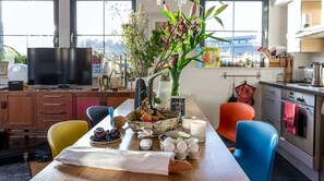 Une cuisine équipée d’une table à manger pour deux personnes, d’un téléviseur et de divers appareils de cuisine.
