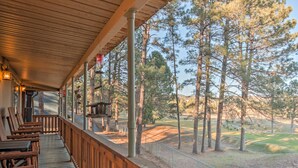 Terraza de madera con mobiliario exterior y vistas a un campo de golf.