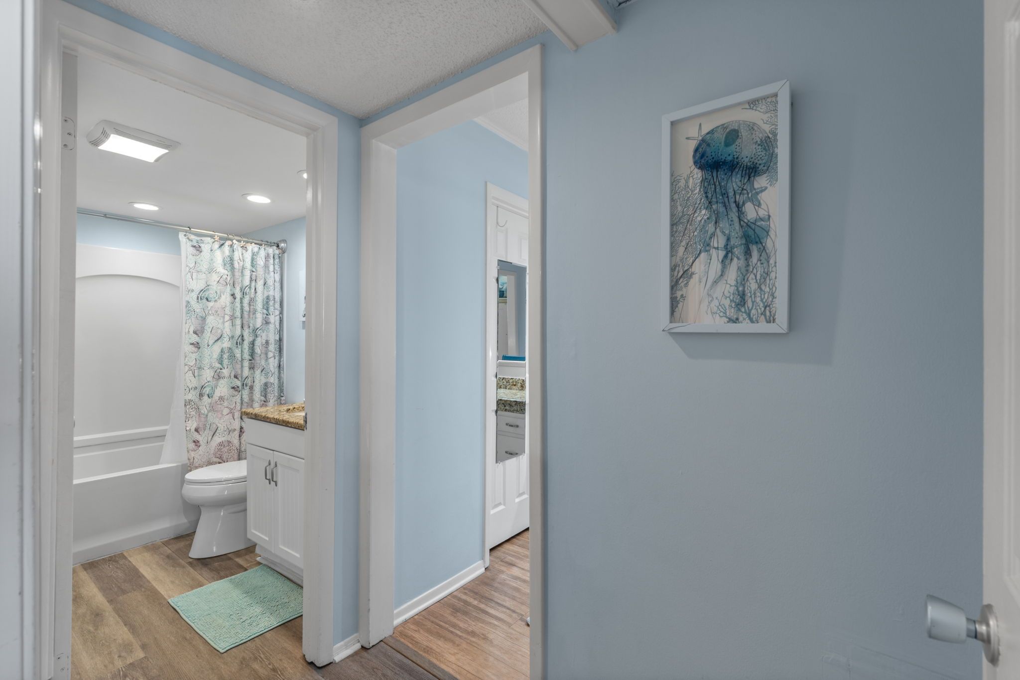 A bathroom with a toilet, a shower curtain, and a sink.