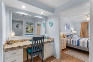A bedroom with a bed, bedside table, lamp, and a painting on the wall. - Beachfront Stay with Amazing Views (Destin)