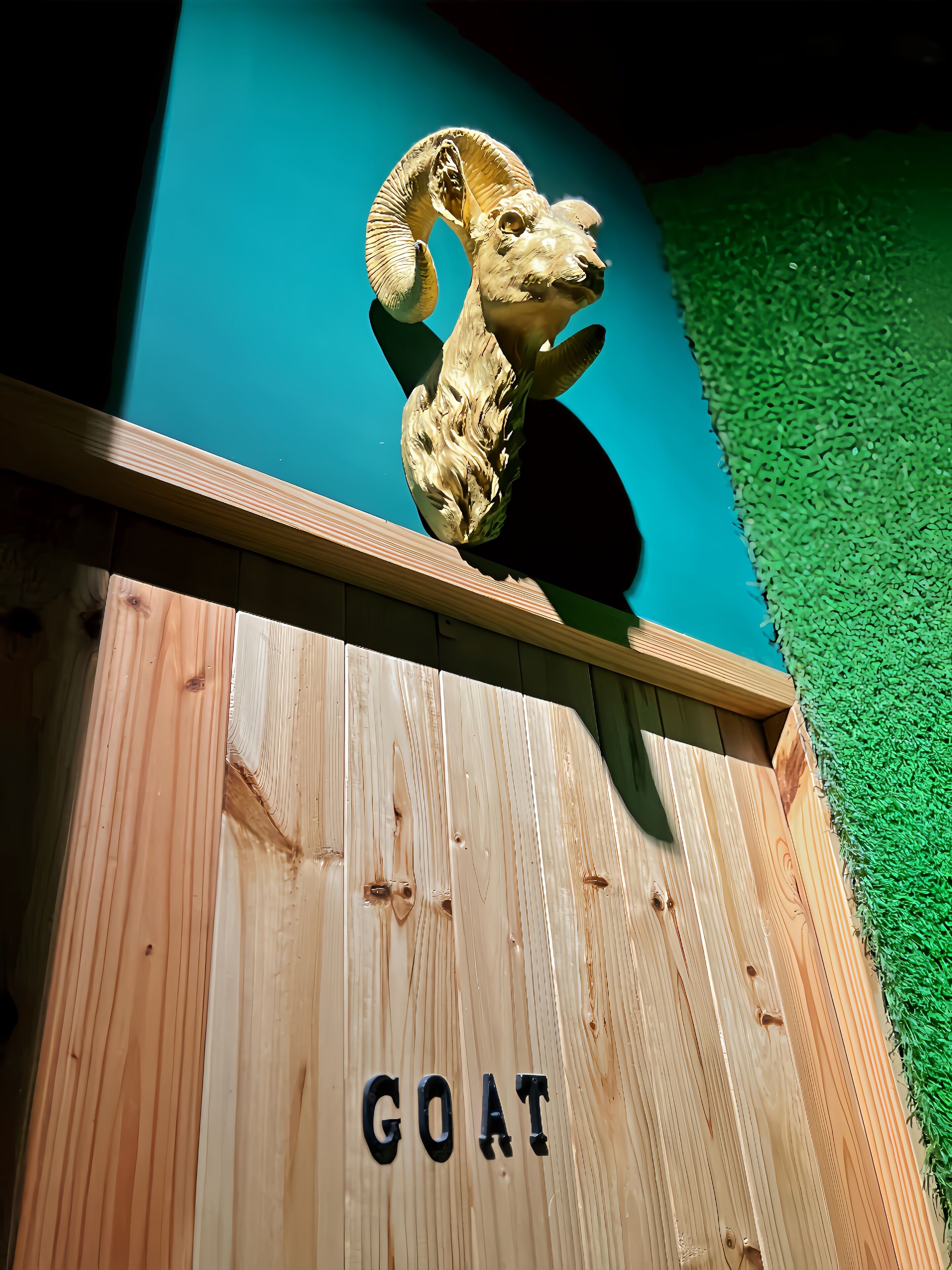 Una estructura de madera con la palabra "GOAT" escrita en ella.