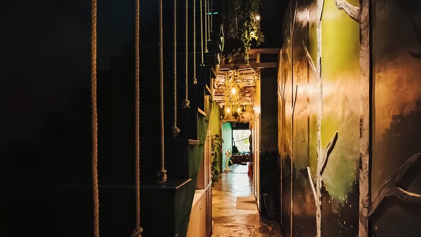 A narrow, dimly lit corridor with a wooden floor, ropes, and hanging lights. - 返璞歸真KO hostel 墾丁背包客棧 (Hengchun)