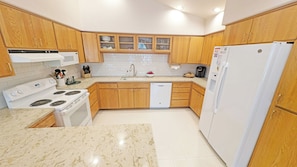 Enjoy cooking in this well-equipped kitchen with a stove, dishwasher, and refrigerator.