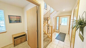 Staircase landing with a carpeted area, wooden railing, and a door with a glass panel.