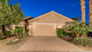 A residential house with a garage, surrounded by a landscaped garden with various plants and a palm tree. - A Beauty in Scottsdale! (Scottsdale)