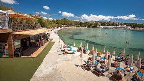 Ein Hotel direkt am Strand mit Außenbereich, Pool und Meerblick.