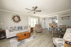 A living room with a sofa, coffee table, and a ceiling fan. - Modern Beachside 1BR | Near Sand, Golf & Tennis (Destin)