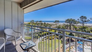 A balcony with a view of the beach, a chair, and a small table. - Oceanfront Villa with Heated Pool! Steps to the Sand (Hilton Head Island)