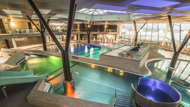 A thermal spa area with a large pool, seating areas, and a wellness center. - Hotel Thermal ŠÍRAVA (Kaluža)