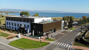 A modern hotel with a flat roof, a restaurant, and a view of a lake.