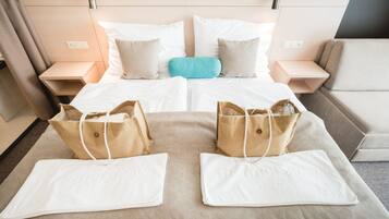 Una habitación de hotel con una cama, dos mesitas de noche, un sofá y dos maletas sobre la cama.