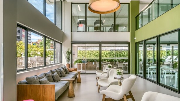 A modern interior with a sofa, chairs, and a dining area. - Porto Kaeté Hotel (Maceió)