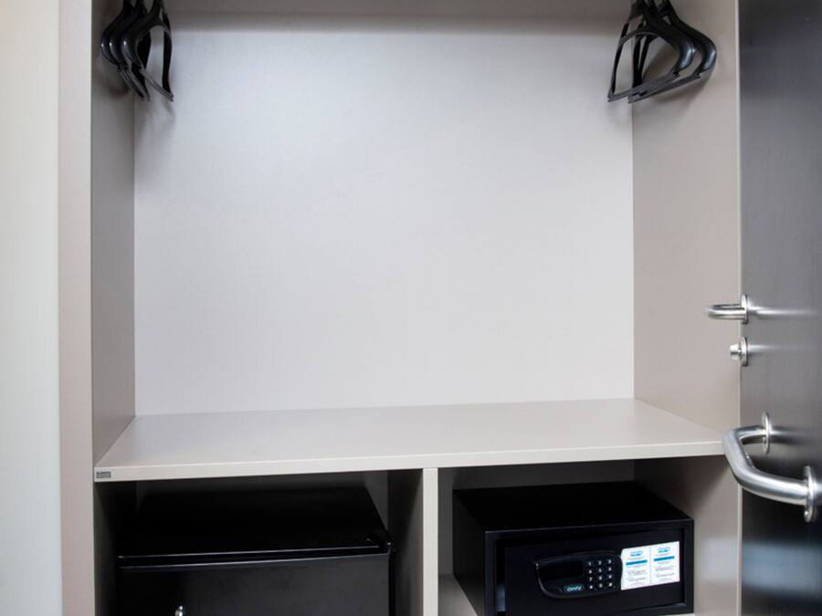 A compact storage unit with shelves, a black appliance, and a microwave.