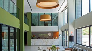 A spacious lobby with a reception desk, seating area, and large windows. - Porto Kaeté Hotel (Maceió)