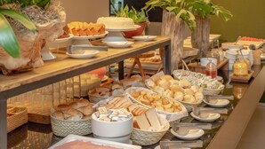 A buffet with various food items including bread, pastries, and meats. - Porto Kaeté Hotel (Maceió)