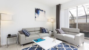 A modern living room with two sofas, a coffee table, and a painting on the wall.