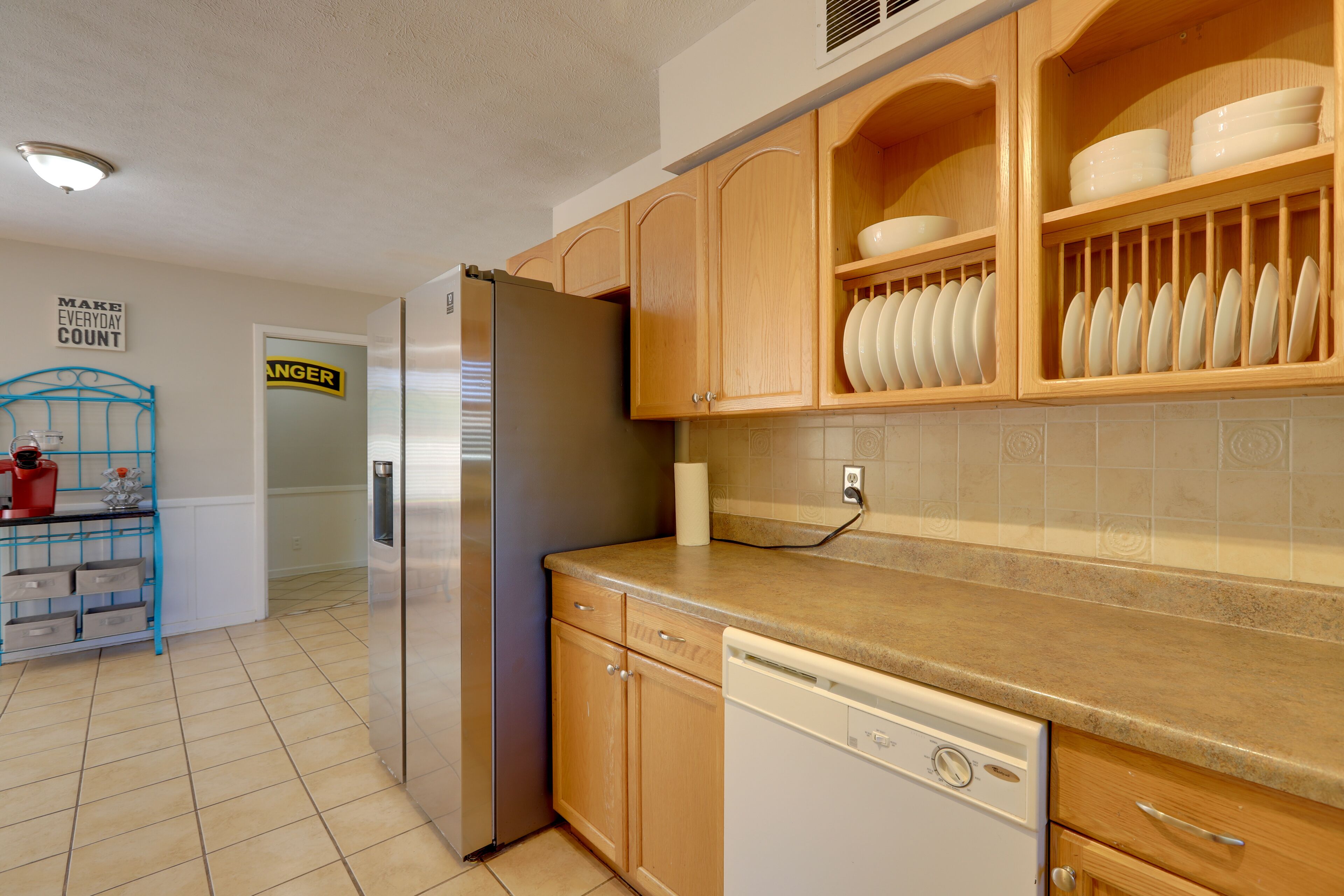 Una cocina con armarios de madera, un refrigerador de acero inoxidable y un lavavajillas.