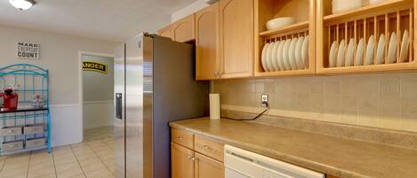 Una cocina con armarios de madera, un refrigerador de acero inoxidable y un lavavajillas.