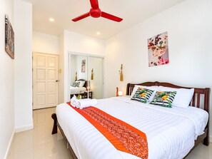 A hotel room with a bed, a ceiling fan, a wardrobe, and a painting on the wall. - Villa Nap Dau Crown Private pool villa for Family and Friends (ต.ฉลอง)