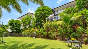 A well-maintained backyard with a soccer goal, a table with chairs, and lush greenery. - Villa Nap Dau Crown Private pool villa for Family and Friends (ต.ฉลอง)