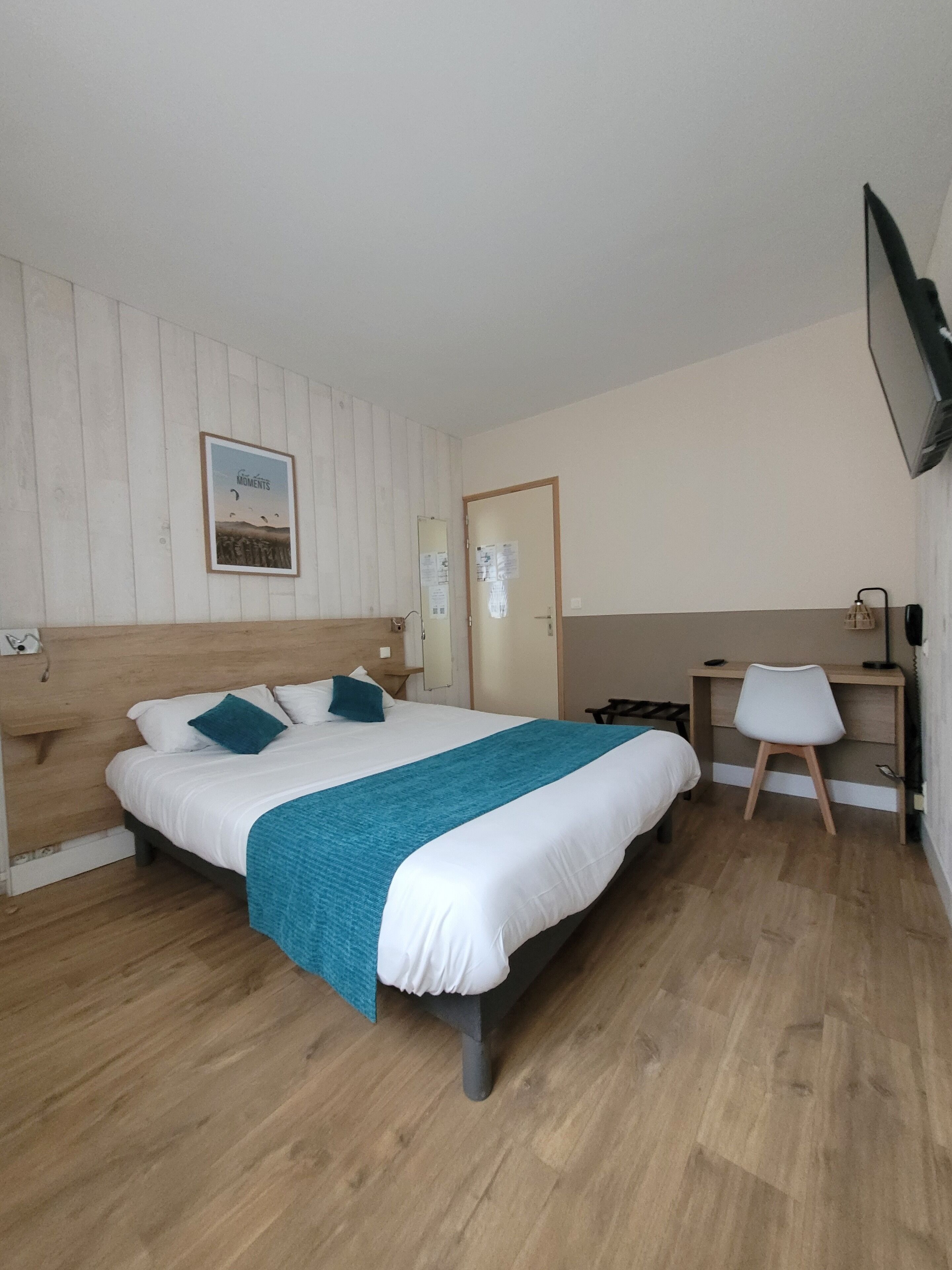 A bedroom with a bed, a desk, and a chair.