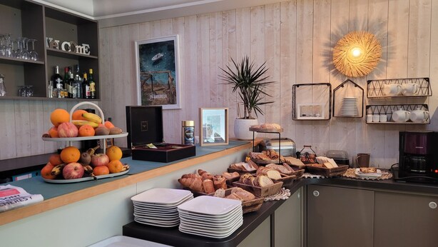 Un bufé de desayuno con frutas, bollería y café.